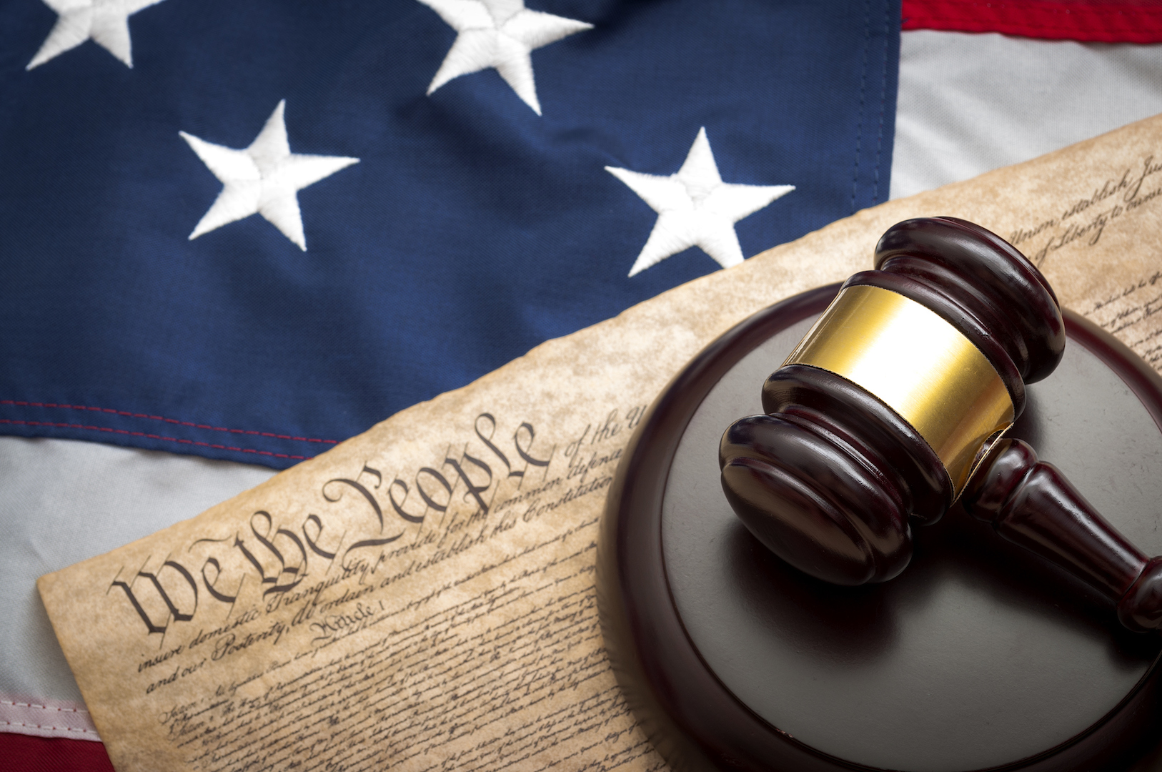 American flag, US constitution and a judge's gavel symbolizing the American justice system or the Judicial Branch of government ( Judiciary )