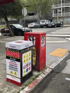 San Francisco Examiner newspaper box with safety message.
